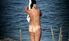 天然乳房裸体主义者在无人的裸体海滩上展示她的身体