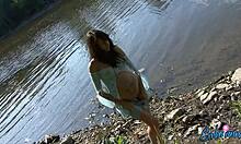 Uma bombshell grávida mostrando seu corpo seminu perto da água