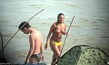 Топлес жена показва гърдите си на нудистки плаж