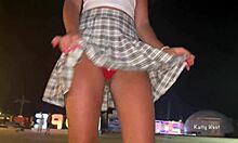 Een jonge brunette pronkt met haar slipje en danst in het openbaar